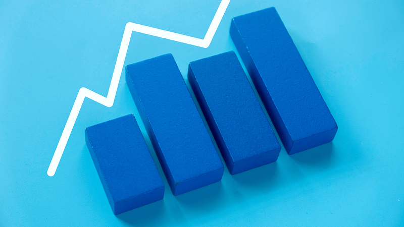 Four blue bars with a rising white graph line, symbolizing growth.